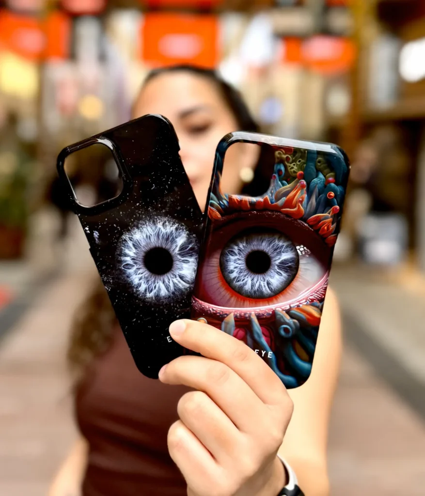 A beautiful girl holding two phone cases with eye2eye irises